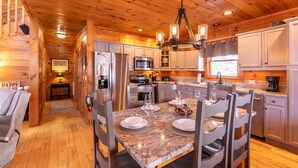 L’intérieur d’une cabane en bois comprend un coin repas, une cuisine et un espace de vie chaleureux.