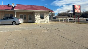 A motel with a red roof, a stone facade, and a sign advertising Big 12 football. - Big 12 Motel Broken Bow Ne (Broken Bow)