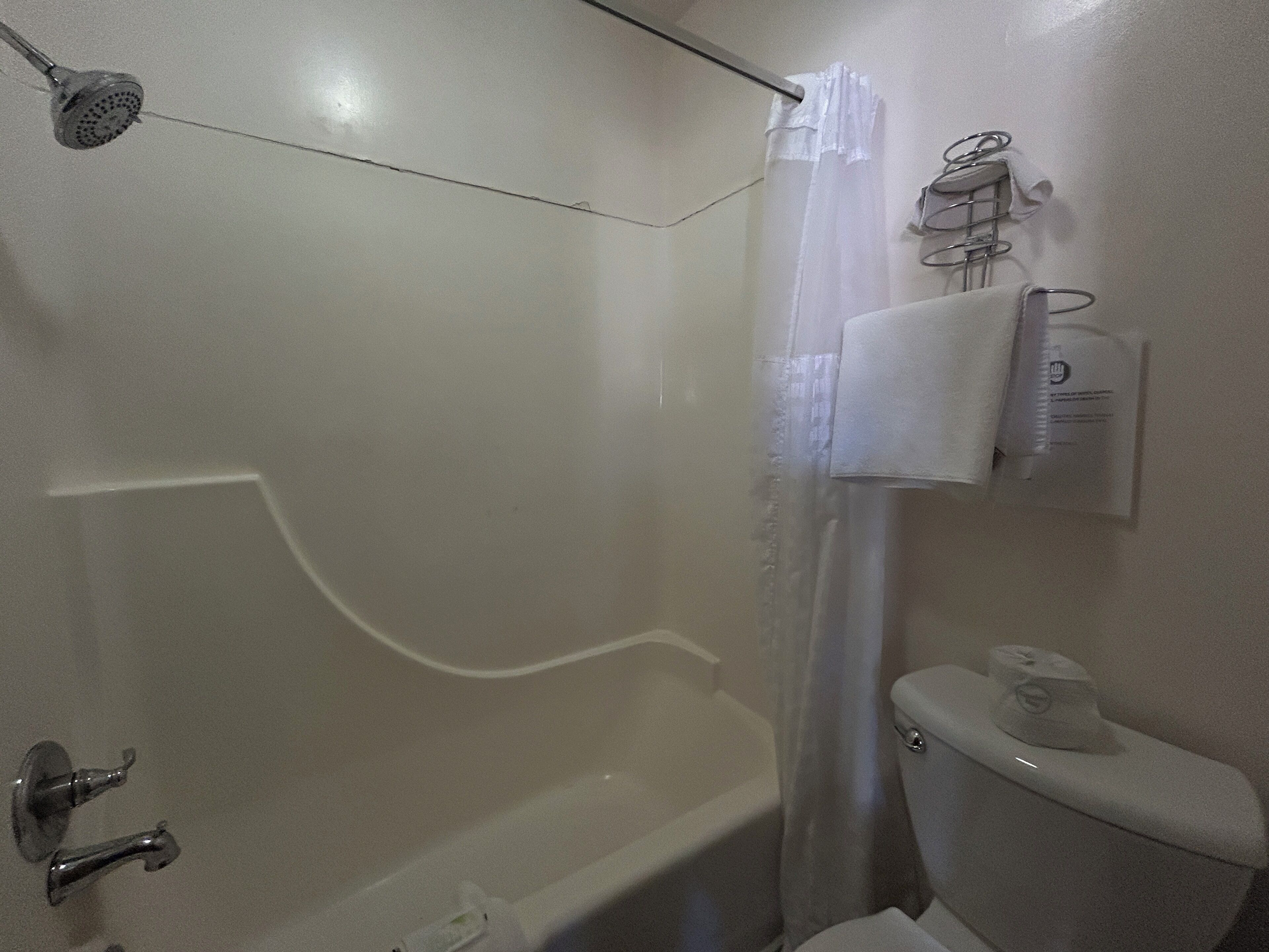Une salle de bain avec une baignoire, des toilettes et un rideau de douche.