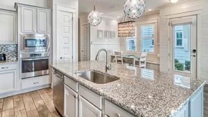 A kitchen with granite countertops, stainless steel appliances, and pendant lighting. - Gorgeous Home in 30A - Golf Cart + Bikes Included (Santa Rosa Beach)