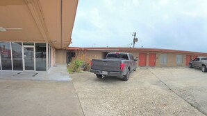 Un motel con zona de estacionamiento de grava, una tienda Walmart al otro lado de la calle y un cielo despejado.