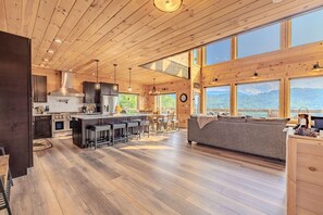 A spacious kitchen with a central island, large windows, and a cozy seating area. - Cabin with Breathtaking Views, Hot Tub & Game Room (Sevierville)