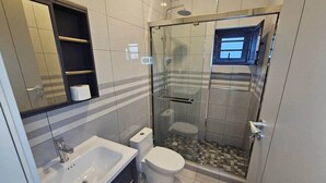 Une salle de bain moderne avec une douche à parois de verre, des toilettes et un lavabo.