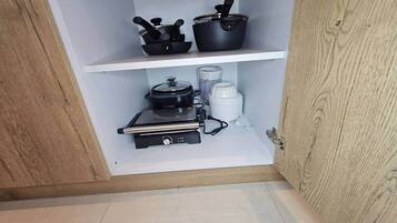 Eine Küche mit Kaffeemaschine, Reiskocher und einem schwarzen Gerät auf der Arbeitsfläche.