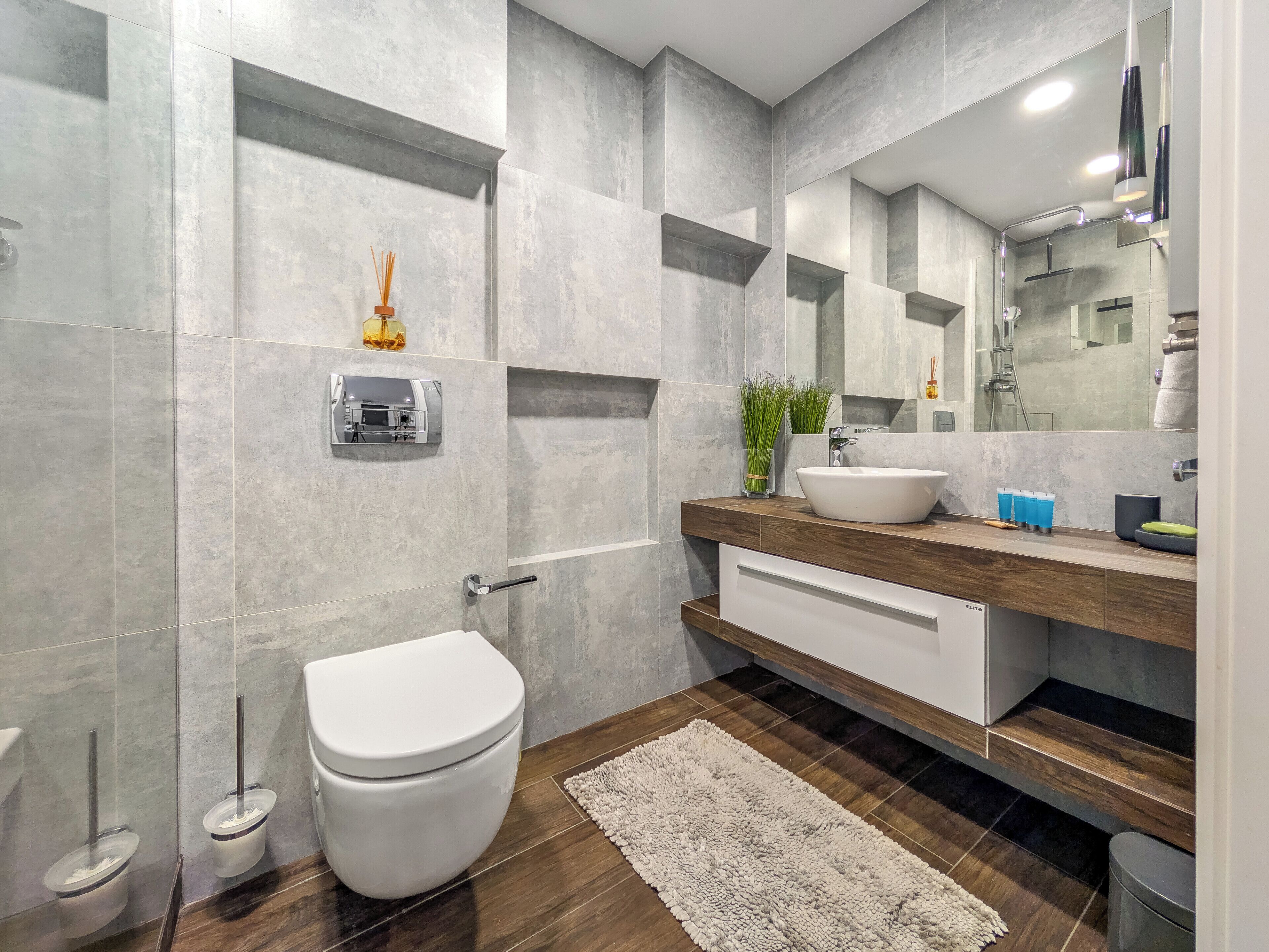 A modern bathroom with a toilet, sink, and shower.