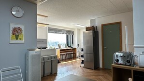 A modern kitchen with a wooden countertop, a refrigerator, a toaster, and a window with a view. - K wave guesthouse only Female 2 (Seoul)
