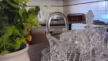 Une cuisine avec une plante en pot, un service à thé et une machine à café.