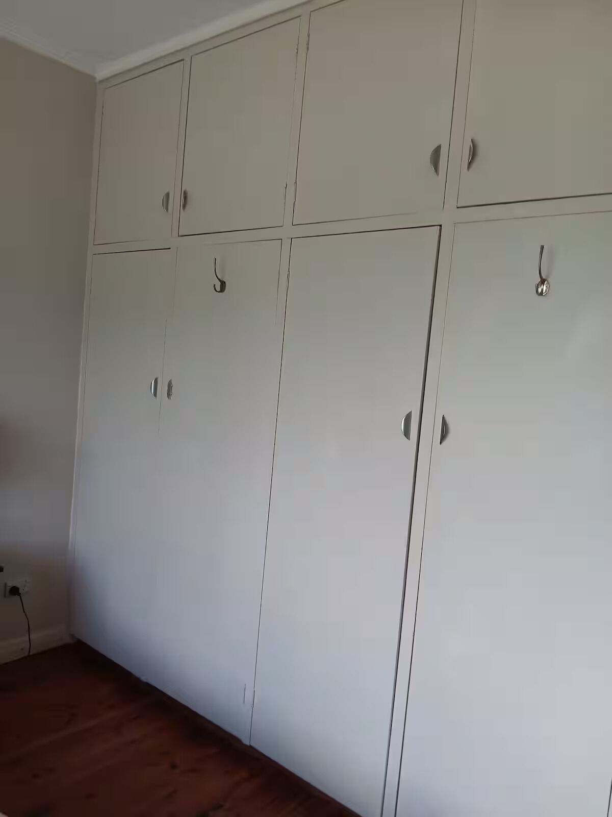 Une pièce dotée d’une grande armoire comprenant de nombreux compartiments et des poignées.