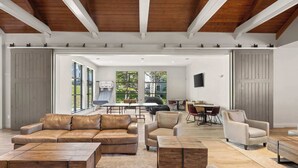 Ein geräumiger Wohnbereich mit Ledersofas, Holztischen und einem Essbereich mit Tisch und Stühlen.
