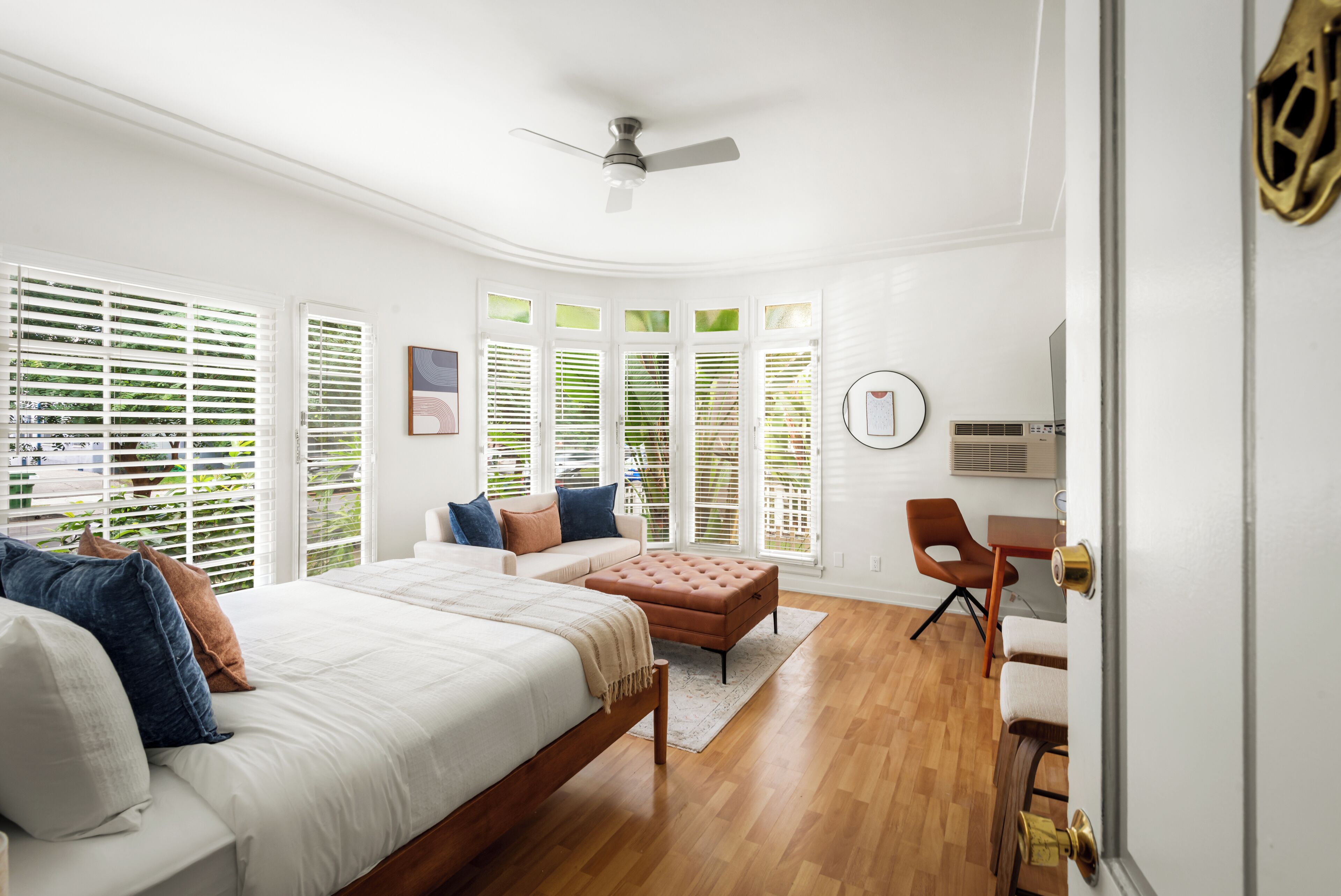 A bedroom with a bed, a desk, and a chair.