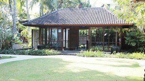 Ein modernes Haus mit einem Ziegeldach, großen Glasfenstern und einem gepflegten Garten.