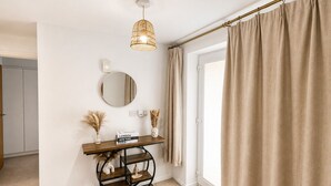 A modern bathroom with a vanity, mirror, and a hanging light fixture. - The Grounded Pearl (Salford)