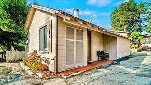 A small, single-story house with a front porch, a chimney, and a window with shutters. - Luxury Carmel Suite  Walk 25 min walk  Carmel Beach 109 (Carmel)