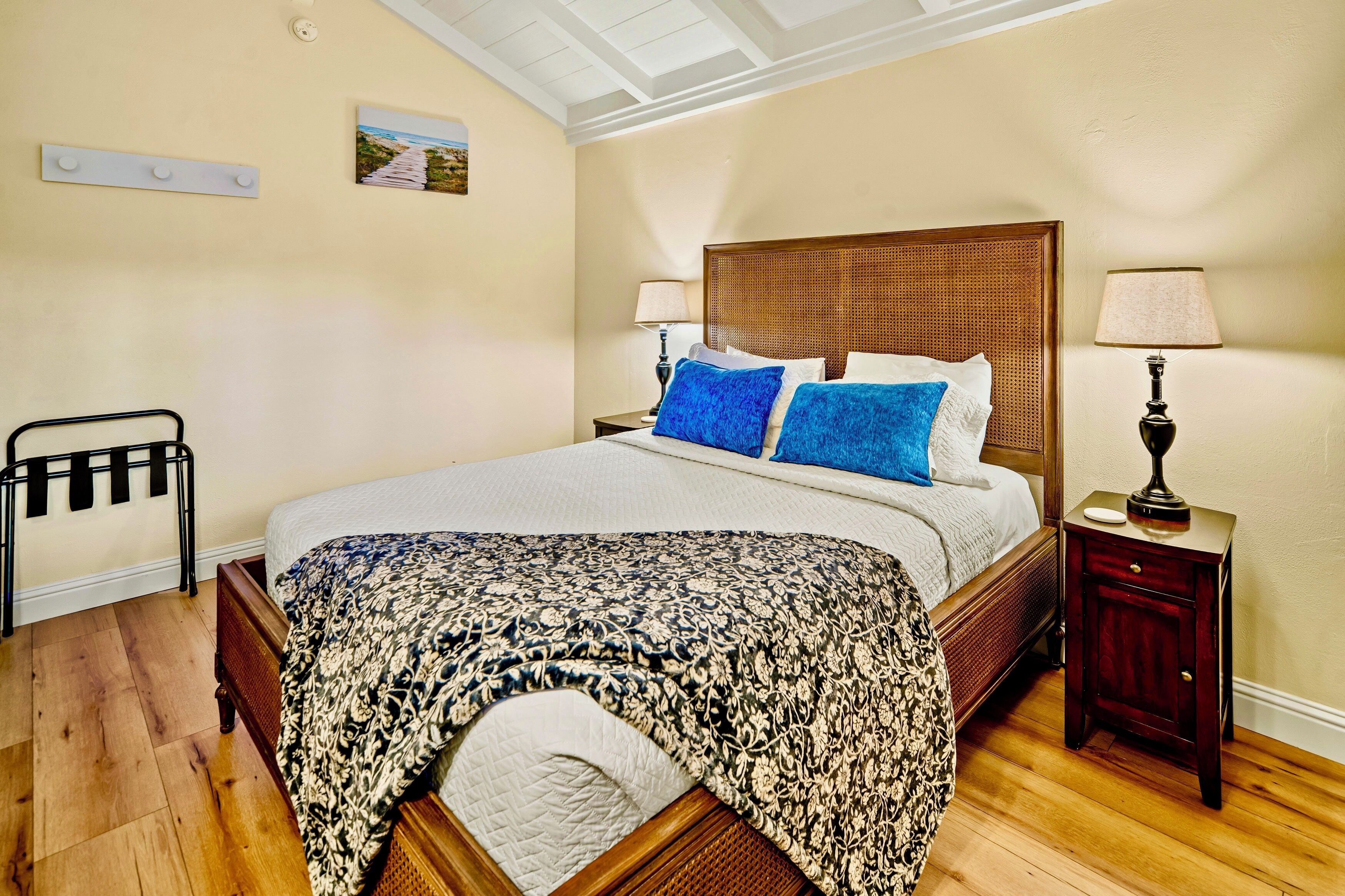 A neatly arranged bedroom with a wooden bed, a bedside table, a lamp, and a chair.
