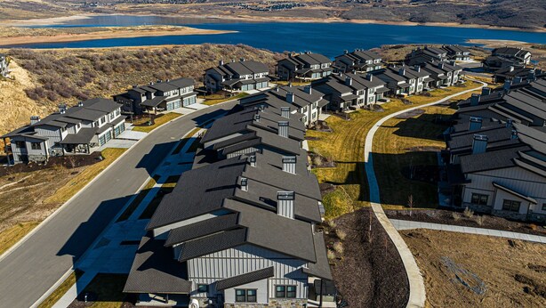 Área residencial com casas, uma estrada e um lago ao fundo.