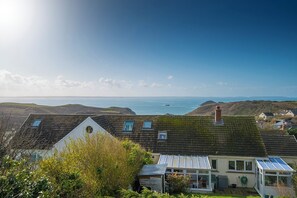 A coastal house with a sloped roof, a conservatory, and a view of the sea. - Ty Peggie, Holiday cottage Solva, Sleeps 4, 2 bedrooms,  bathrooms (Haverfordwest)