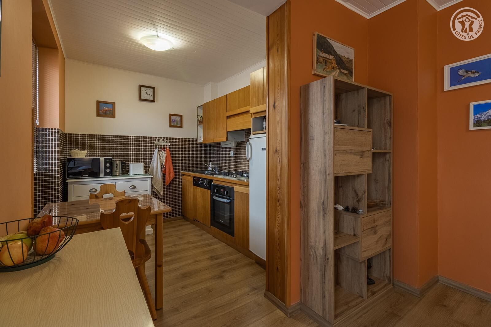 A compact kitchen with wooden cabinets, a microwave, a toaster, and a sink.