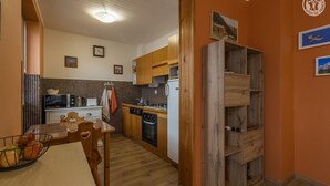 Eine kleine Küche mit Holzausstattung, einer Mikrowelle, einem Toaster und einem Spülbecken.