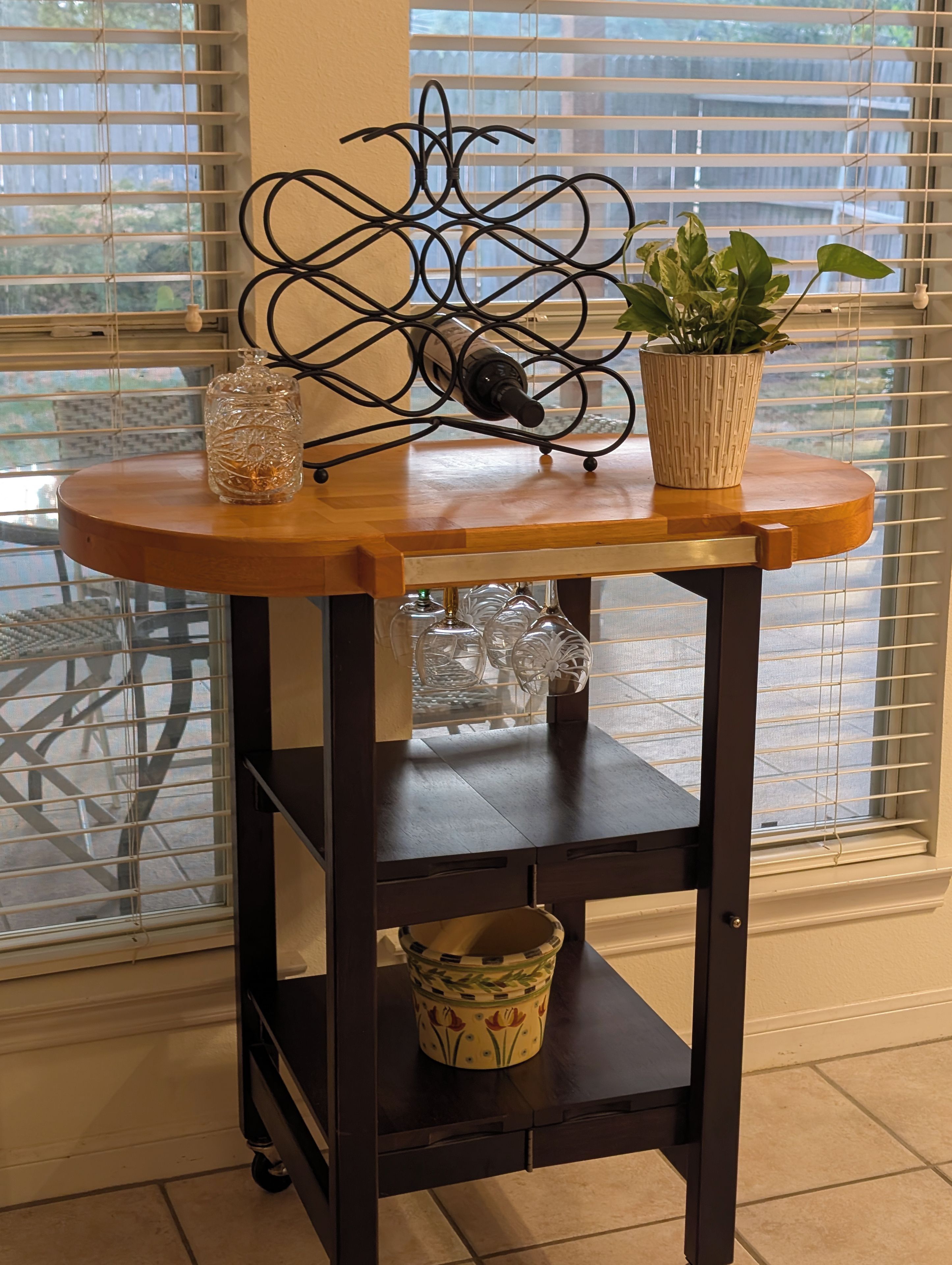 Une table en bois, un vase en verre, une plante en pot et un objet décoratif en métal.