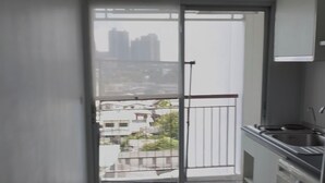 Uma cozinha pequena e moderna, com máquina de lavar, pia e janela com vista para a paisagem urbana.