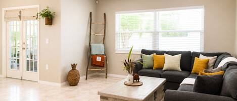 A living room with a sofa, coffee table, and a ladder against the wall.