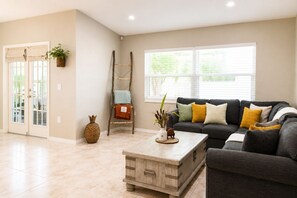 A living room with a sofa, coffee table, and a ladder against the wall. - Your home away from home II (New Port Richey)