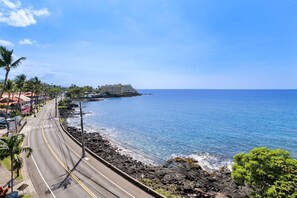 Eine Küstenstraße mit Blick auf das Meer und einem Hotel im Hintergrund.