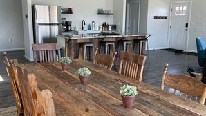 Un comedor amplio con una mesa de madera, sillas y plantas en macetas.