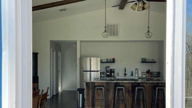 Una cocina amplia con una isla central, taburetes de bar y electrodomésticos modernos.