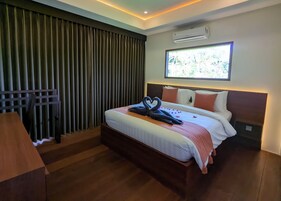 Habitación de hotel con una cama grande, un escritorio, una ventana con vistas y un equipo de aire acondicionado.