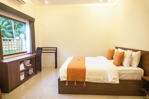 A neatly made bed with a wooden headboard, a bedside table, and a window with a view of greenery. - Semu Villa (Pemenang)