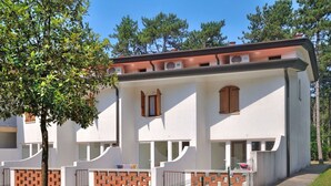 Ein zweistöckiges Gebäude mit weißer Fassade, Ziegelakzenten und zahlreichen Fenstern.