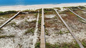 Une plage avec des promenades en bois qui mènent à la rive.