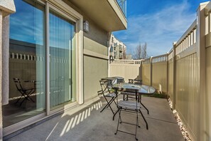 A patio with a glass door, a table, and chairs. - 3-Bedroom Condo in the Heart of the City (Salt Lake City)