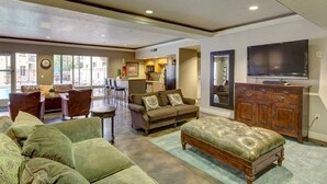 A spacious living area with a sofa set, a wooden cabinet, and a television. - Downtown Condo Close to Everything (Salt Lake City)