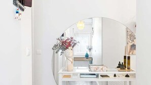 A hallway with a white console table, a mirror, and a wooden floor. - GuestReady - Charming Porto Retreat for Families (Porto)