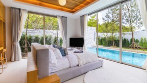 A modern bedroom with a large bed, a TV, and a view of a swimming pool. - Luxpride4  (Si Sunthon)