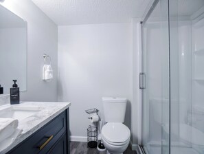 Ein modernes Badezimmer mit einem мраморной раковиной, einer Toilette und einer Duschkabine aus Glas.
