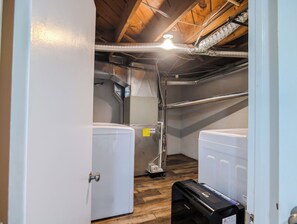 Une buanderie équipée de deux machines à laver, d’un sèche-linge et d’un système de ventilation.