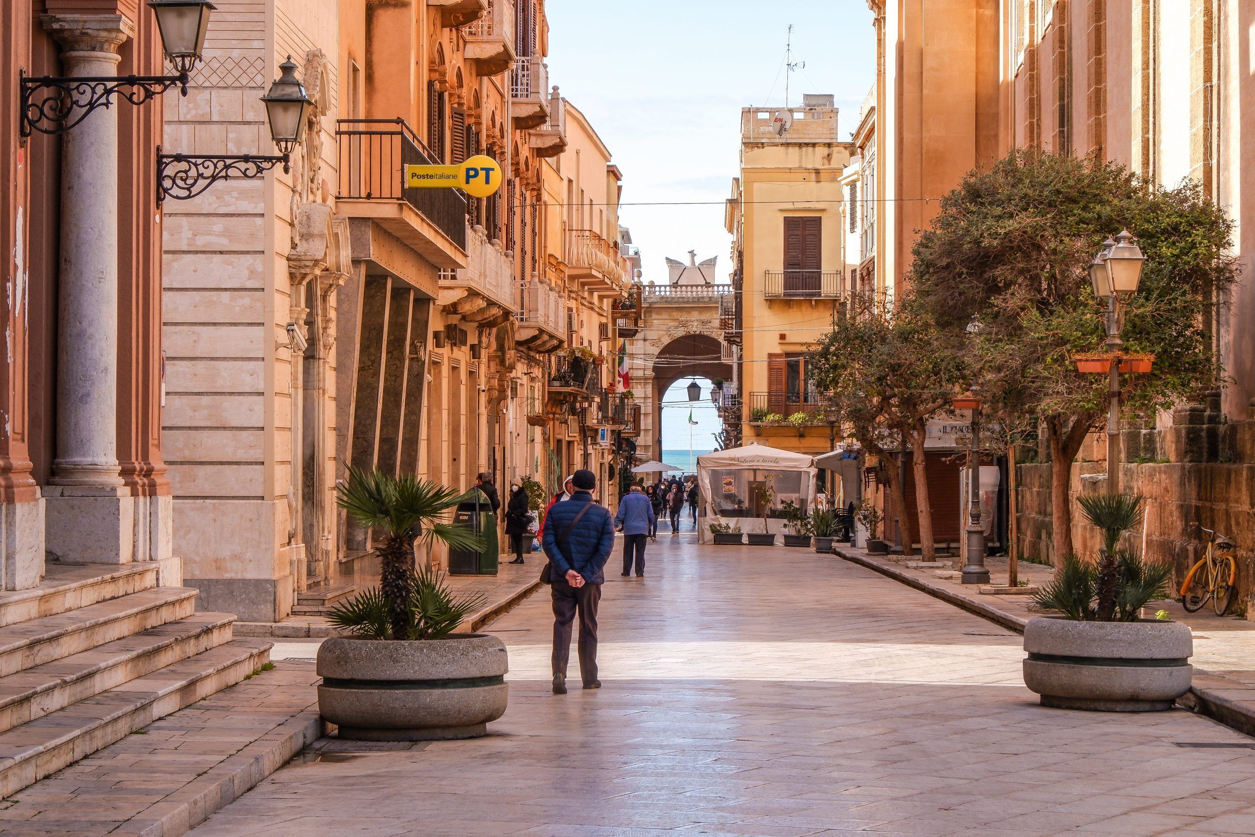 A street with buildings, a pedestrian, and a bicycle.