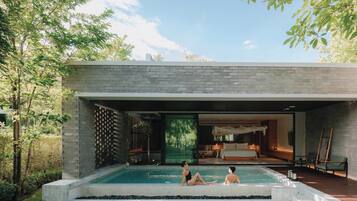 Una casa moderna con piscina, una camera da letto e un soggiorno.