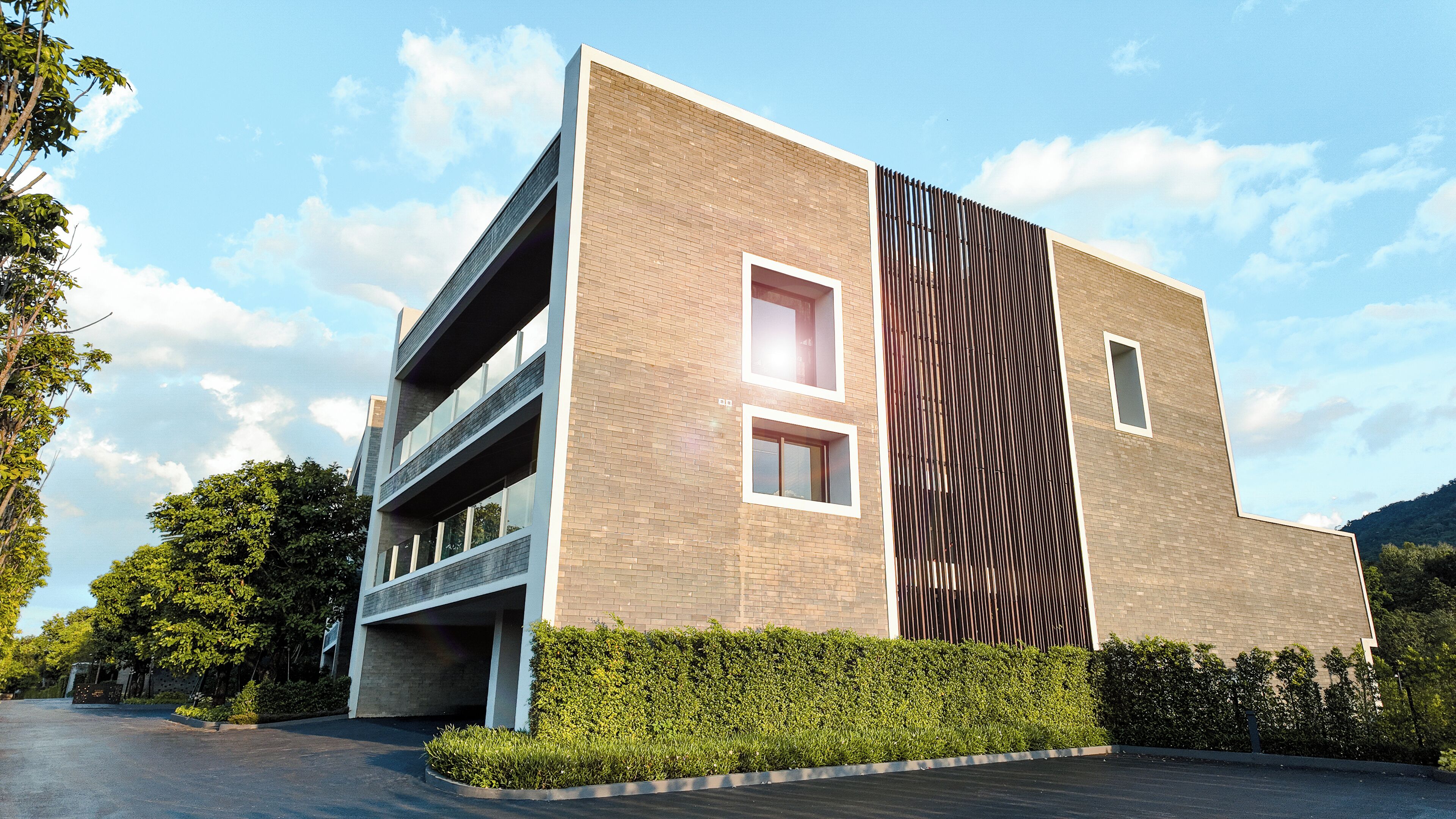 A modern building with a brick facade, multiple windows, and a large vertical design element.