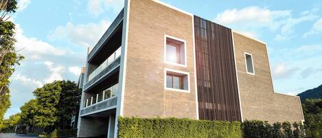 A modern building with a brick facade, multiple windows, and a large vertical design element.