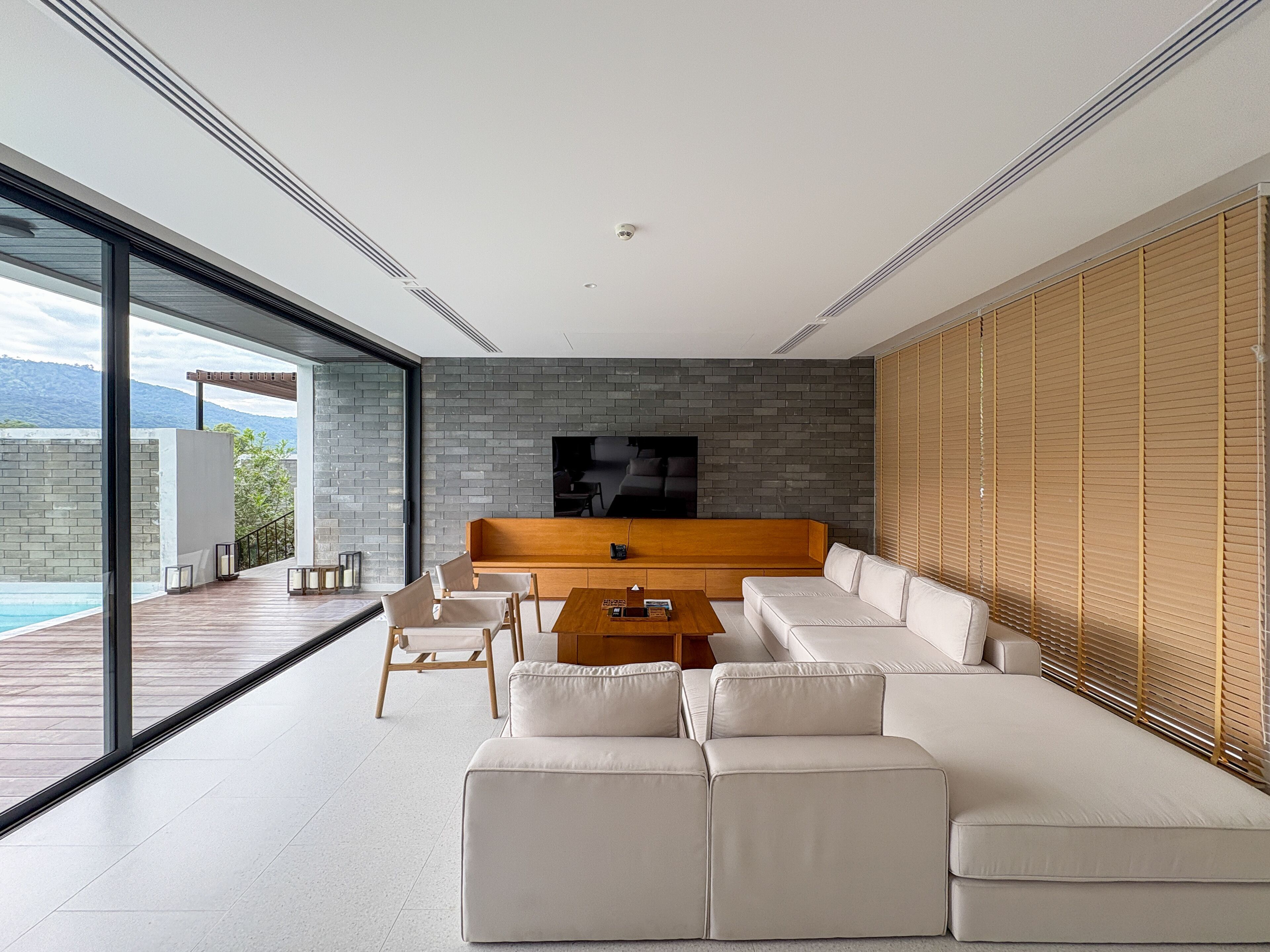 A modern living room with a large sofa, a coffee table, and a TV.