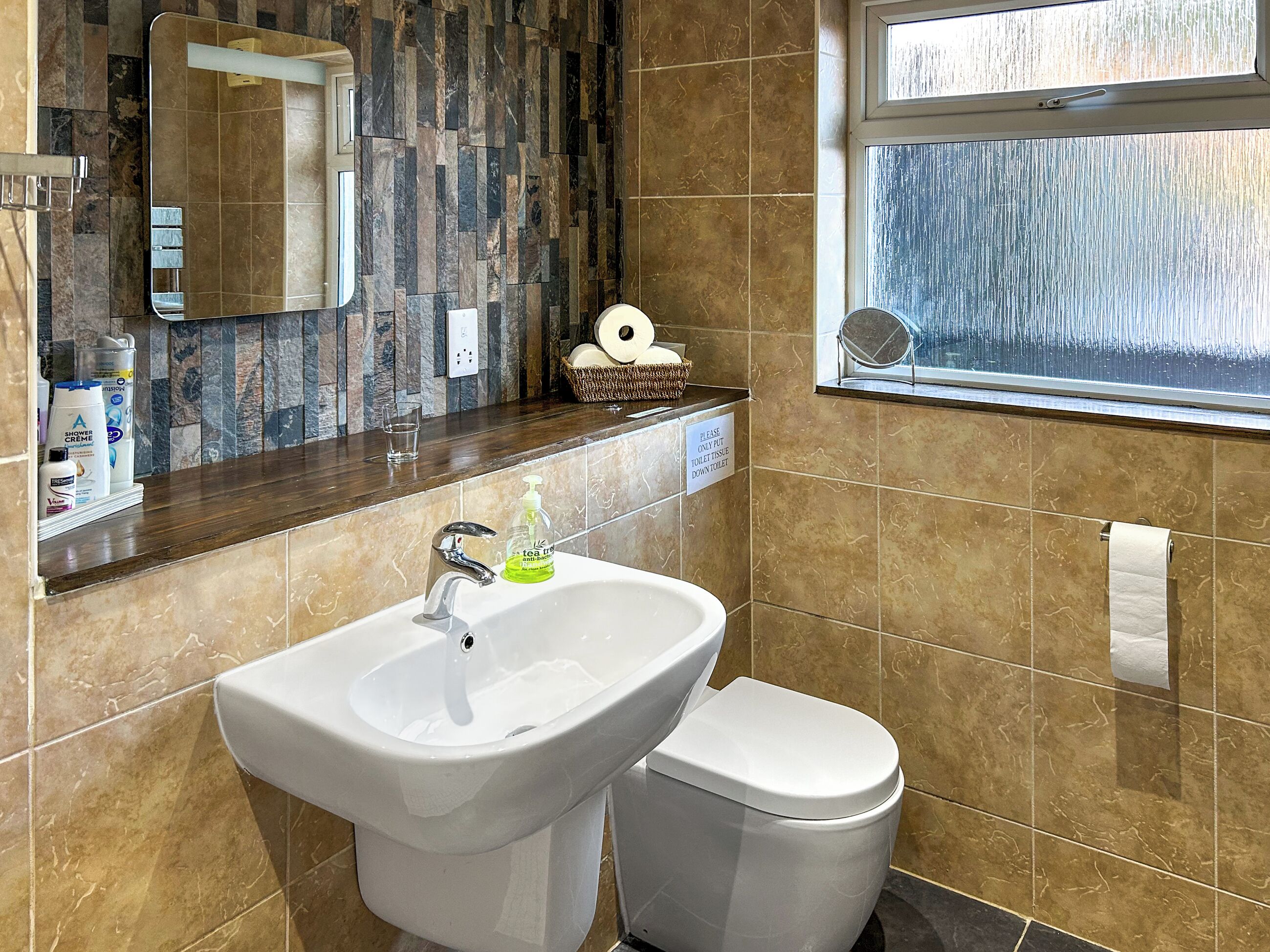 Une salle de bain avec un lavabo, des toilettes et un miroir.