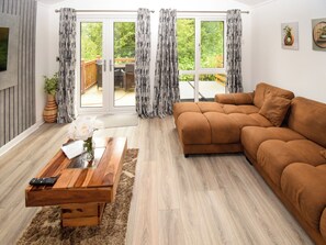 Ein Wohnzimmer mit einem braunen Sofa, einem Holztisch und einem Fernseher.