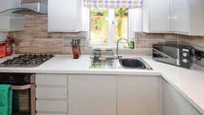 Eine moderne Küche mit Gasherd, Backofen, Spüle und Toaster.