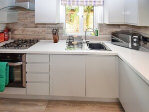 Eine moderne Küche mit Gasherd, Backofen, Spüle und Toaster.