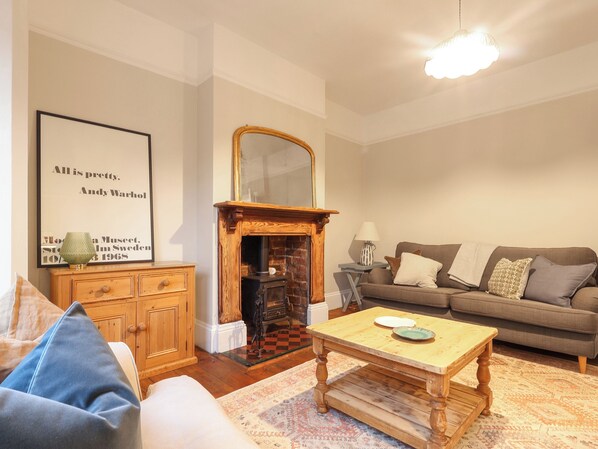 A living room with a fireplace, a sofa, a coffee table, and a framed quote on the wall.