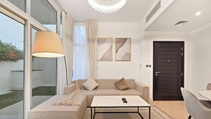 Una sala de estar moderna con un sofá, una mesa de centro y un ventanal grande.